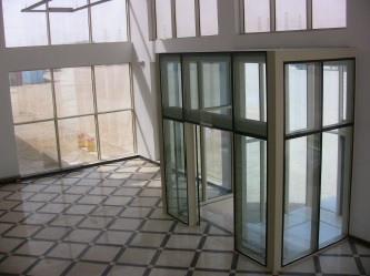 Double-height glazed atrium representing EPTM LTD architectural, curtain-wall, skylight, entrance-system and interior-finish coordination scope