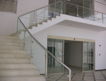 Modern staircase representing EPTM LTD architectural interior detailing, glass-balustrade, handrail, finish and automatic-door coordination scope